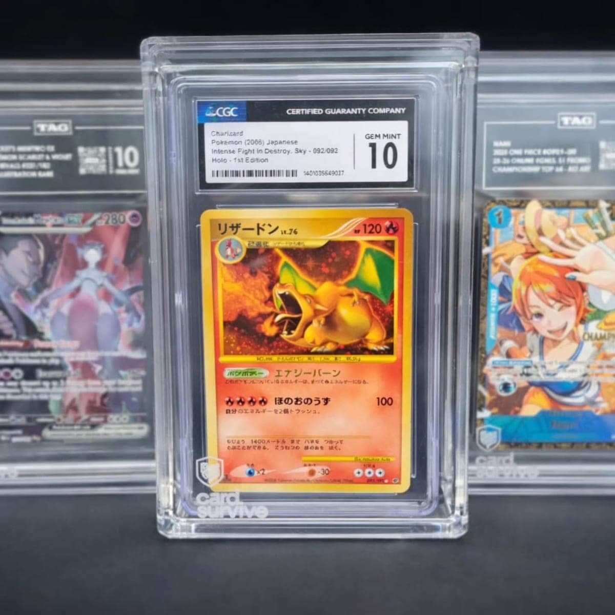 A CGC 10 graded Japanese Charizard card installed in The Tank protector, with TAG-graded cards in Tanks on either side.